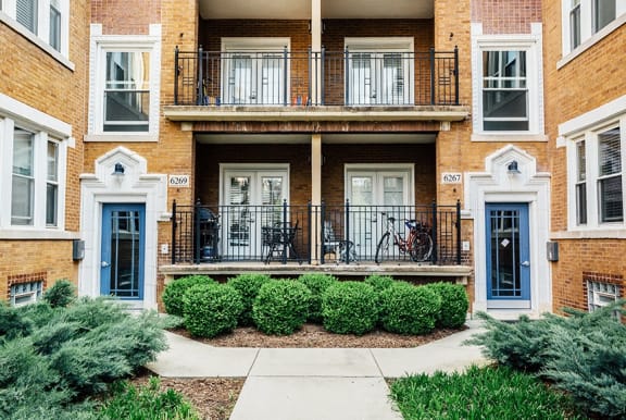 an apartment building with a balcony and a bike parked in front of it