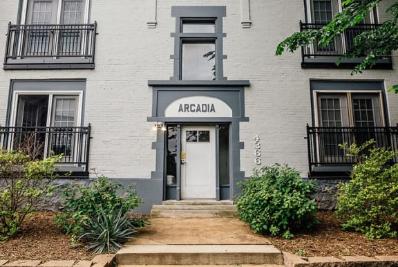 the front of an apartment building with a white door