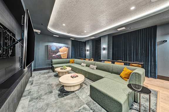 a room with a couch and tables and a large screen on the wall at The Mera, Minnesota 55426