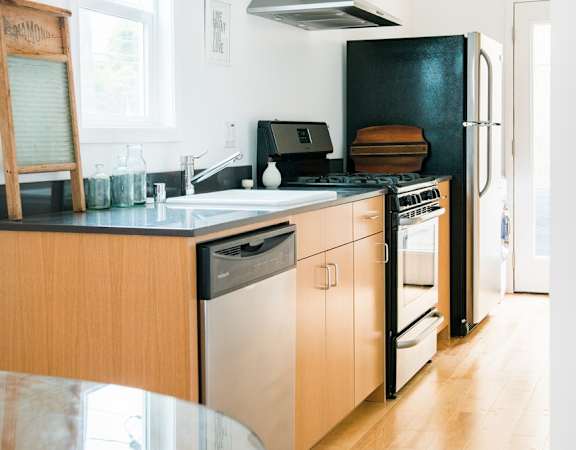 a kitchen with wooden cabinets and a black refrigerator