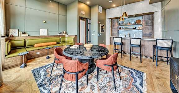 a living room with a table and chairs and a kitchen