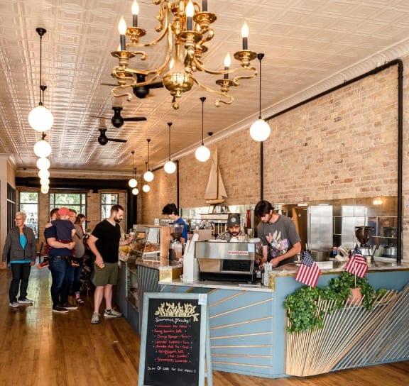 the inside of a restaurant with people ordering at the counter at One West Drive Apartments, Excelsior, Minnesota
