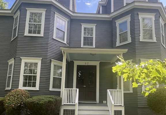 A house with a grey exterior and a black door.
