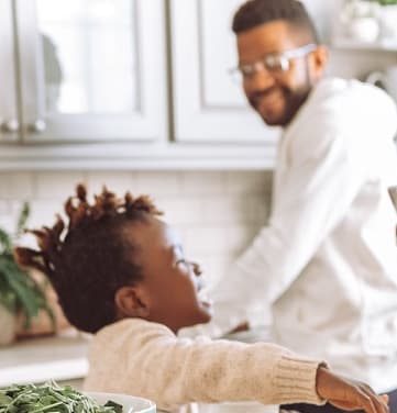 a family in the kitchen making a pizza together