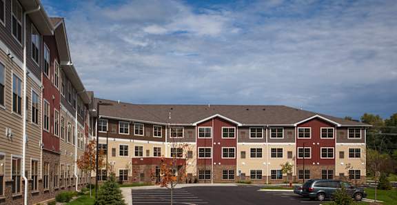 an exterior view of an apartment building with a parking lot