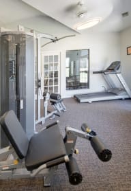 a gym with exercise equipment and windows in a building at Boulder Pointe Apartments in Middletown, NY 10940