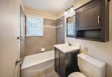 A bathroom with a white tub, sink, and toilet at Rivercrest Apartments, Piscataway  08854