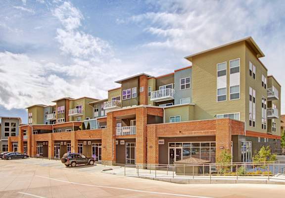 A large multi-story building with a parking lot in front.