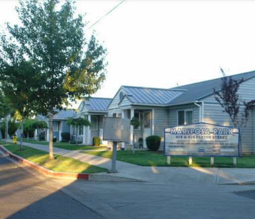 the facade of a building with a driveway and a gate
