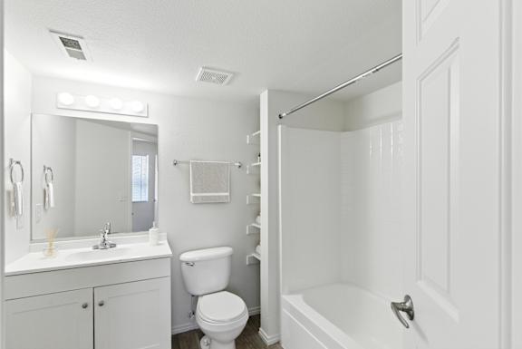 A white bathroom with a toilet, sink, and bathtub.