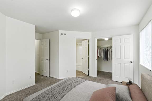 A bedroom with a bed, a wardrobe, and a mirror.