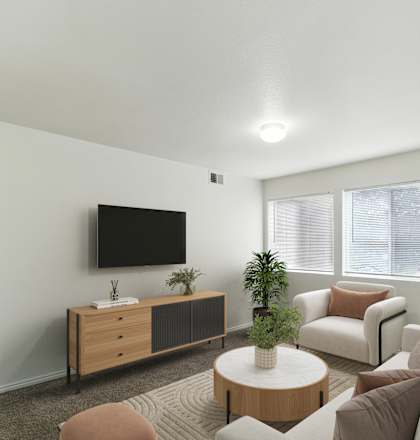 A living room with a white couch, a wooden table, and a flat screen TV mounted on the wall.