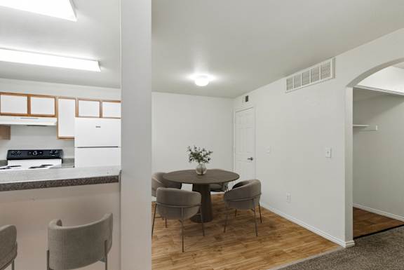A dining area with a round table and grey chairs.