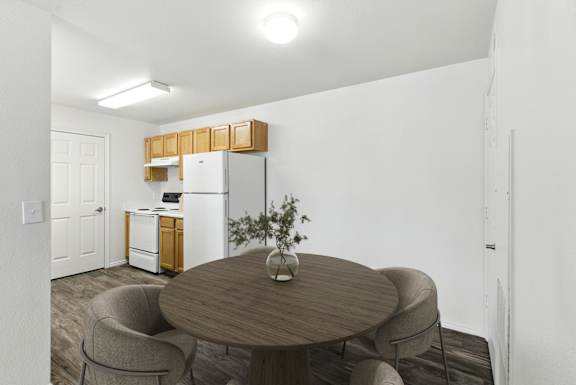 A kitchen with a white refrigerator and wooden cabinets.