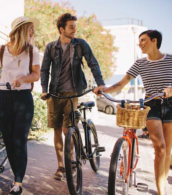 Three people riding bicycles on a sunny day.
