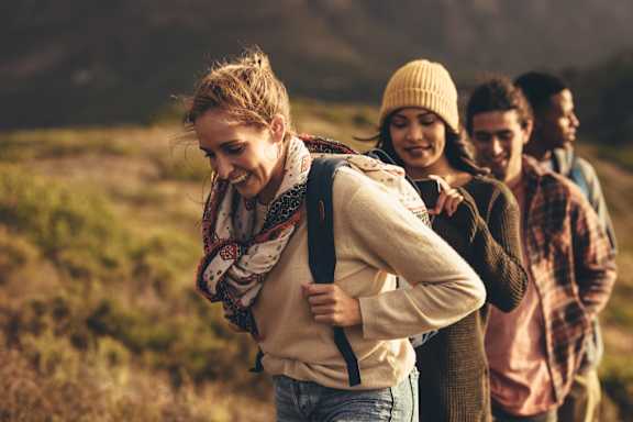 A group of people are hiking in a field.