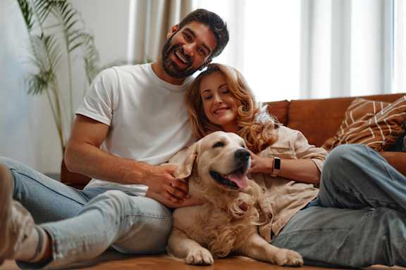 a man and woman sitting on a couch with a dog