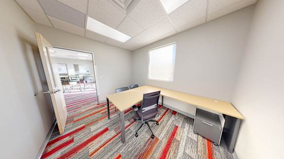 A room with a desk and a chair.
