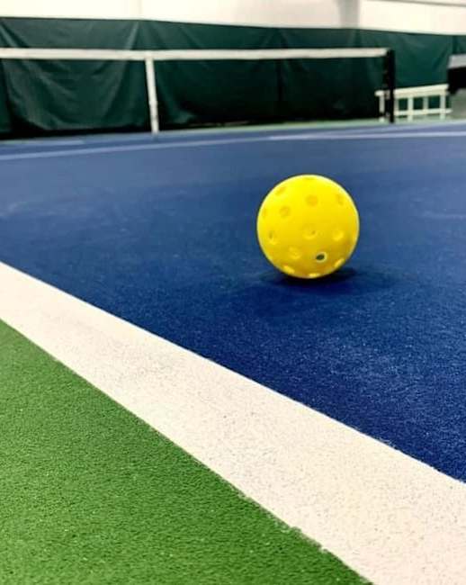a yellow ball on a tennis court