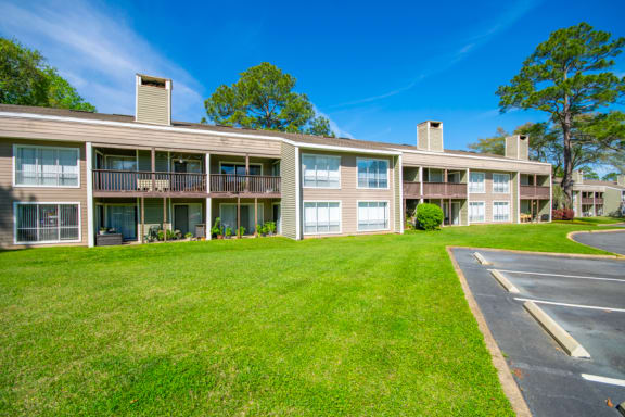 an exterior view of a condominium building with a green lawn