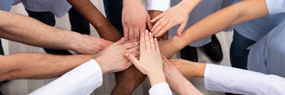 A group of people with their hands stacked on top of each other.