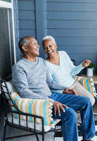 Two people sitting on a porch.