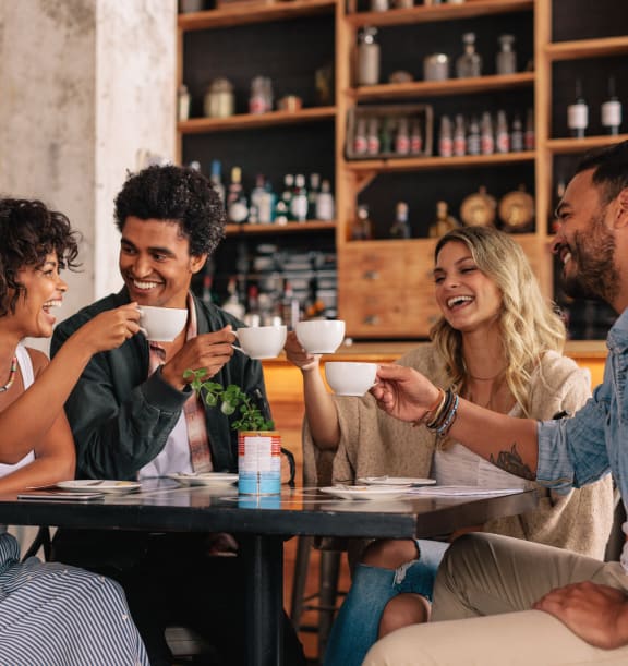 group of people sitting at a table in a restaurant drinking coffee