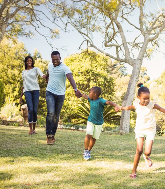 family running together in a park at GrandView Flats and Townhomes, Granger