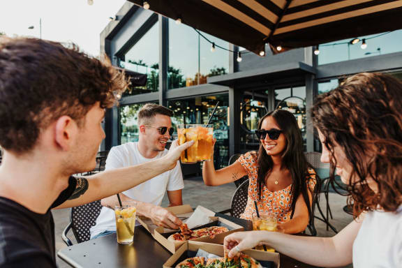 people sitting at a table eating food and drinking beer