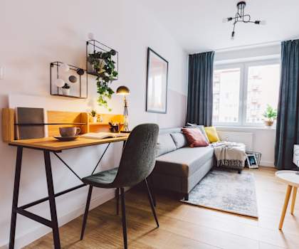 A living room with a grey chair and a wooden table.