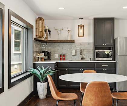 A kitchen with a table and chairs and a refrigerator.