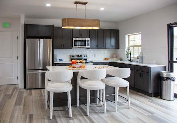 A kitchen with a white table and chairs.
