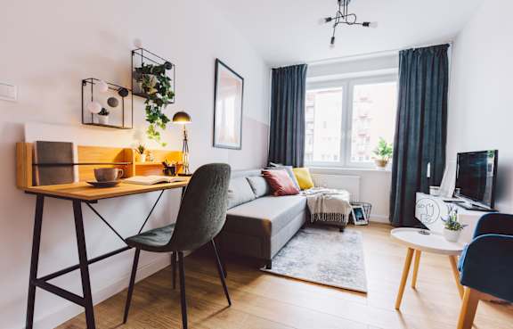 A living room with a grey chair and a wooden table.