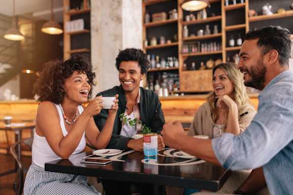 Four people are sitting at a table in a restaurant.