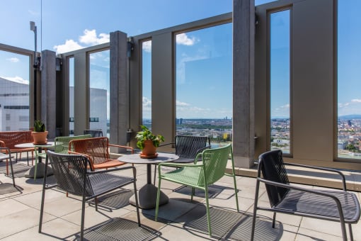 a terrace with tables and chairs and a view of the city