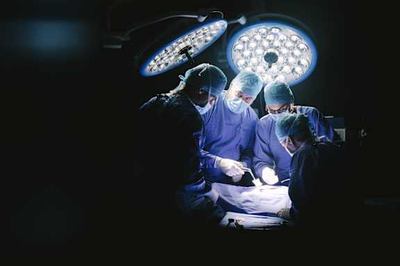 A group of surgeons performing an operation in an operating room.