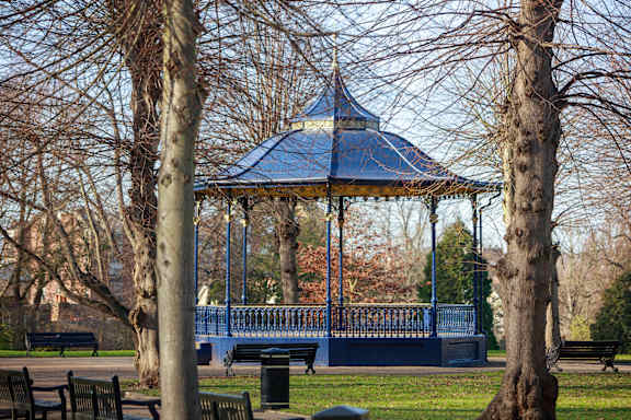 a park with a lake and trees and a bus