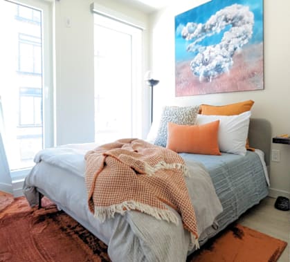 a bedroom with a bed and a painting on the wall