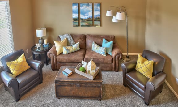 a living room with a brown couch and yellow and blue pillows