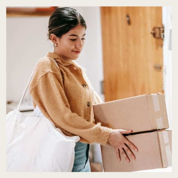 A girl carrying a stack of boxes at BLVD Beltline, Calgary, Alberta, T2G 2K4