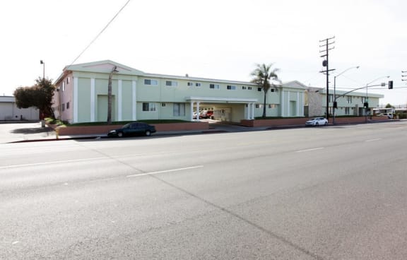 a large white building with a street in front of it a kitchen with white cabinets and a white stove top oven