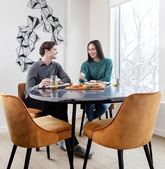 Two people are sitting at a table with food and drinks at Southpark on Whyte, Edmonton, AB