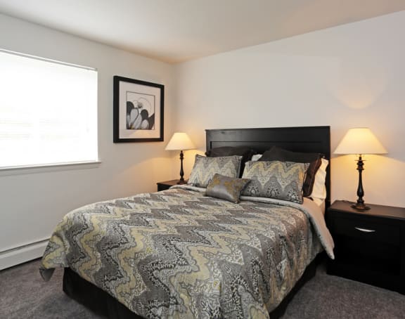 a bedroom with a bed and two lamps