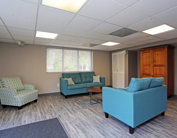 a waiting room with blue couches and chairs