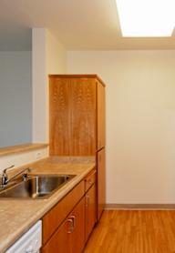 A kitchen with a white refrigerator, white stove, and wooden cabinets.