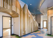 Thumbnail 4 of 7 - A hallway with a blue ceiling and a wooden staircase.