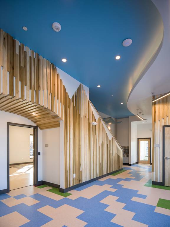 A hallway with a blue ceiling and a wooden staircase.