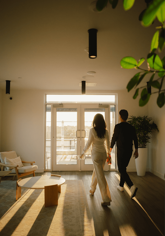 A man and woman are walking through a brightly lit hallway.