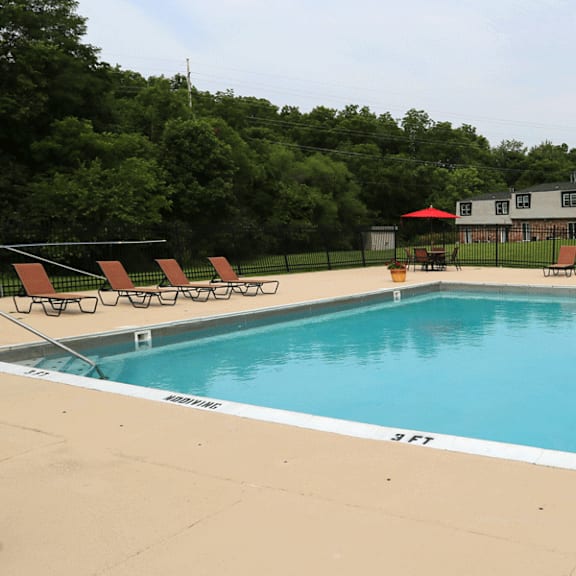 Outdoor swimming pool with lounge chairs at Red Coach Village in Springfield, OH