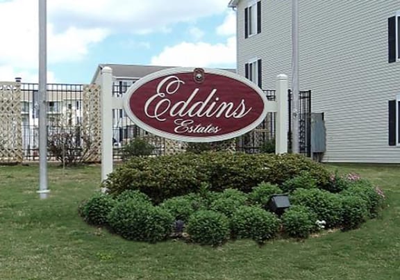 a sign for a coca cola store in the grass